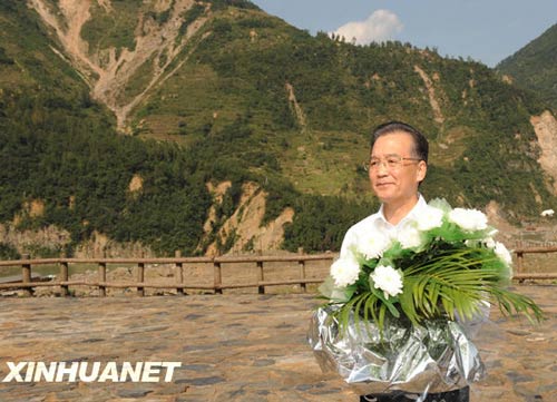 溫家寶總理十分關注災后重建進展情況。在國慶節和中秋佳節即將來臨之際,他第8次踏上了一直牽掛的這塊土地。在9月24日至26日的三天時間里,他奔波穿行于地震重災區的城鄉間,為節省時間,吃飯盡量安排在火車上;連續兩個晚上主持召開會議,就災后恢復重建的一系列重大問題進行研究部署。這是9月24日,溫家寶在青川縣紅光鄉東河口村地震遺址祭奠臺獻花。新華社記者黃敬文攝